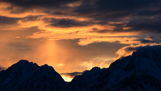 The Setting Sun Flares Bright Orange Amidst Smoke From Fires On The Idaho Side Of The Teton Mountains