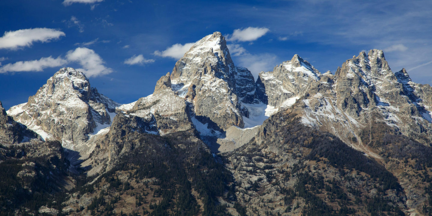 The Grand Teton Range Is An Impressive Skyline Against A Bright Blue Sky
