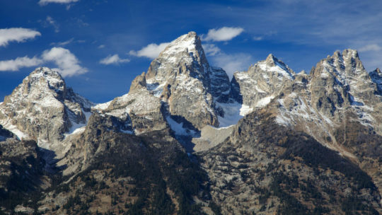 The Grand Teton Range Is An Impressive Skyline Against A Bright Blue Sky